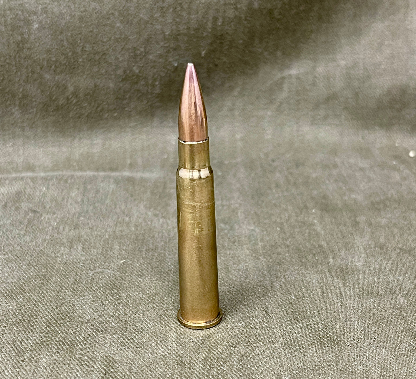 Bronze bullet casing on a textured gray background