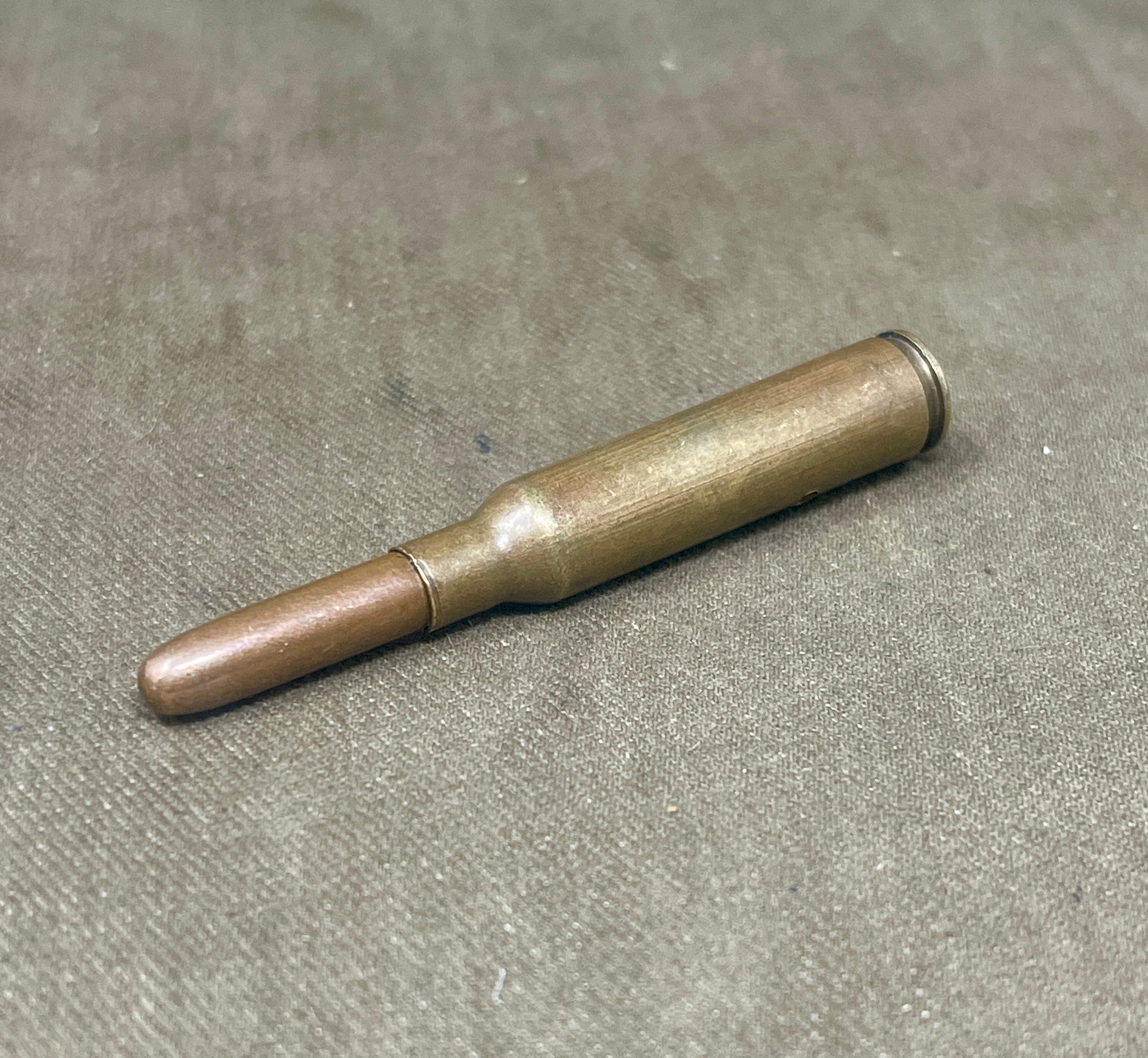 Metallic cylindrical object on a gray surface