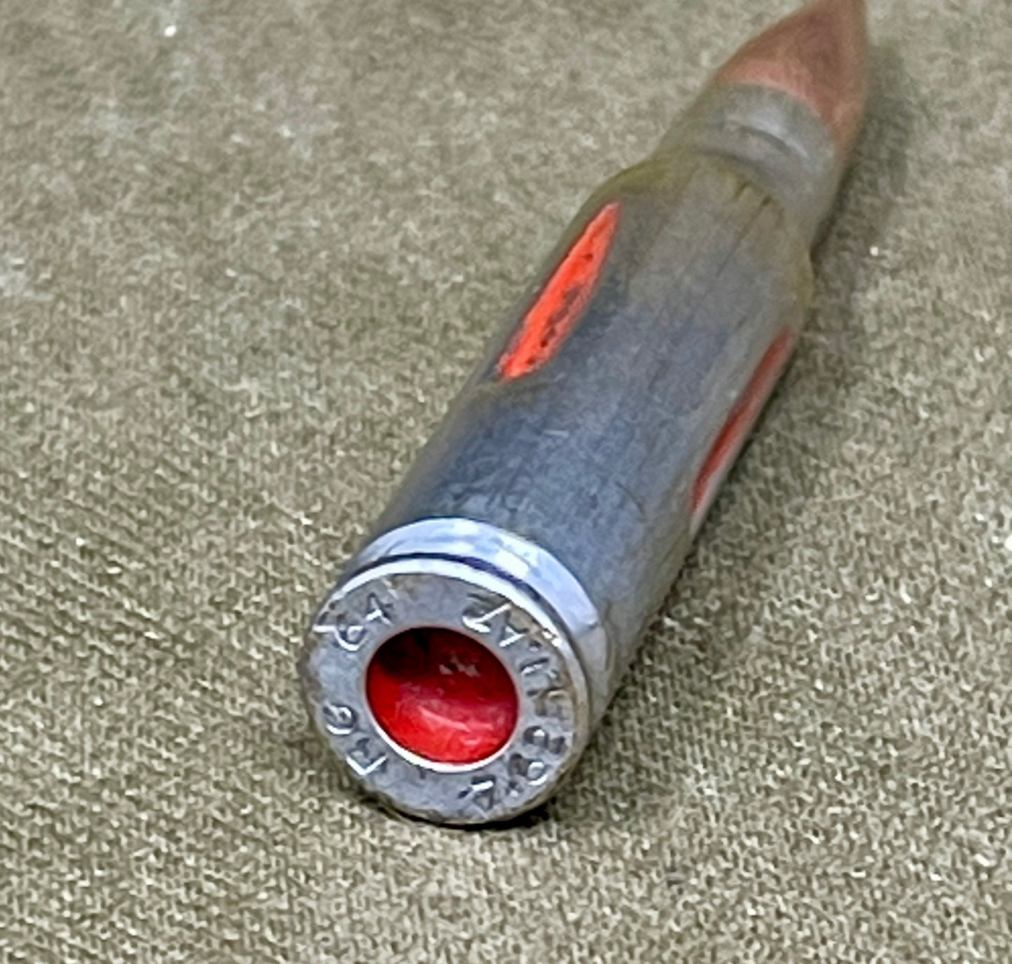 Close-up of a rifle bullet casing on a textured surface