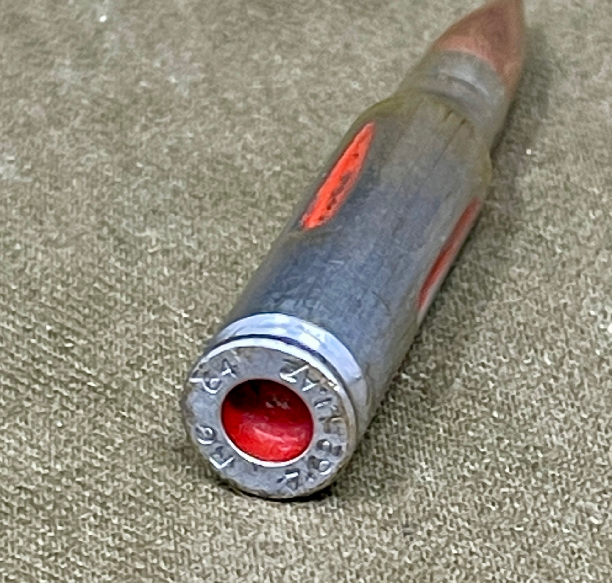 Close-up of a rifle bullet casing on a textured surface
