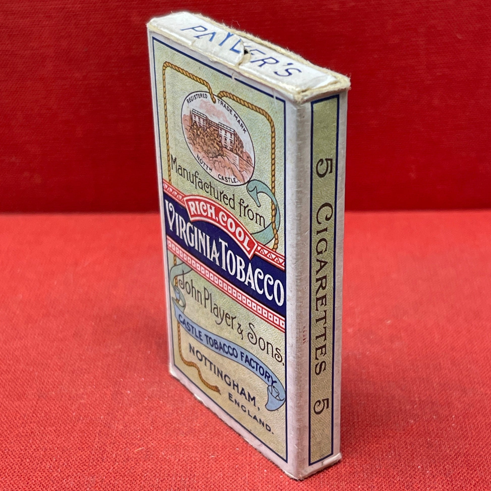 An empty packet for 10 Player's Medium Navy Cut cigarettes. The front has an ocean scene and a sailor framed in a life belt.