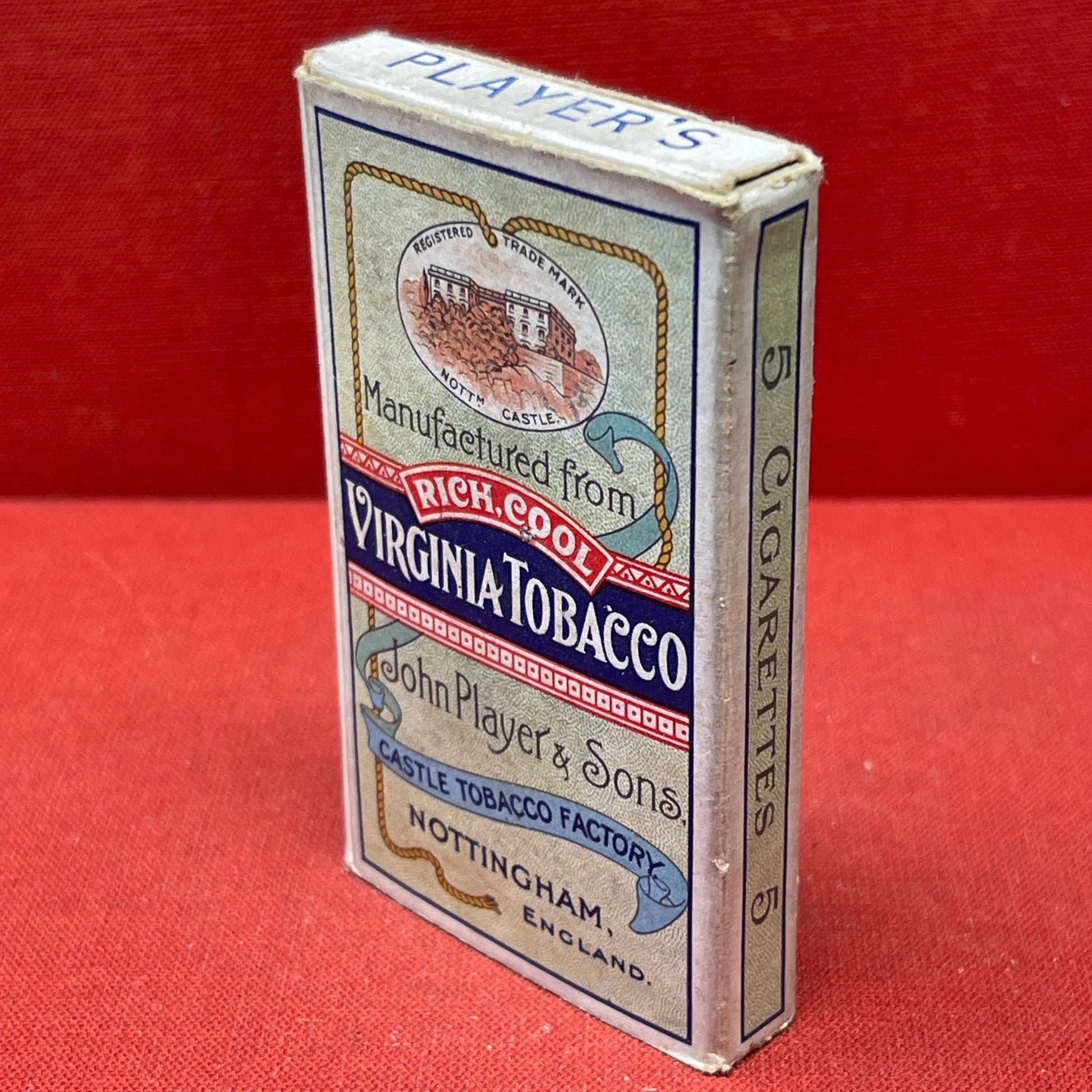 An empty packet for 10 Player's Medium Navy Cut cigarettes. The front has an ocean scene and a sailor framed in a life belt.