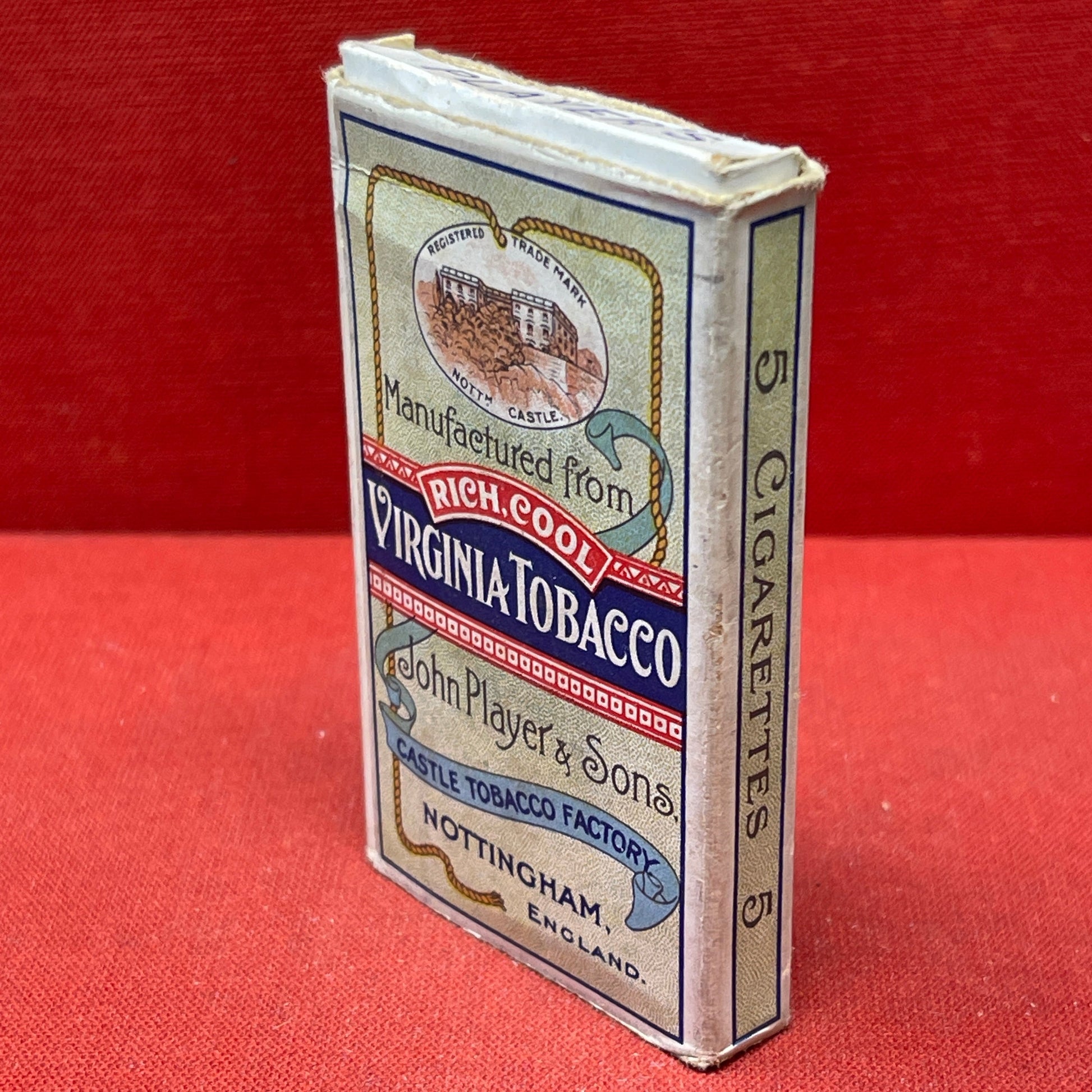 An empty packet for 10 Player's Medium Navy Cut cigarettes. The front has an ocean scene and a sailor framed in a life belt.