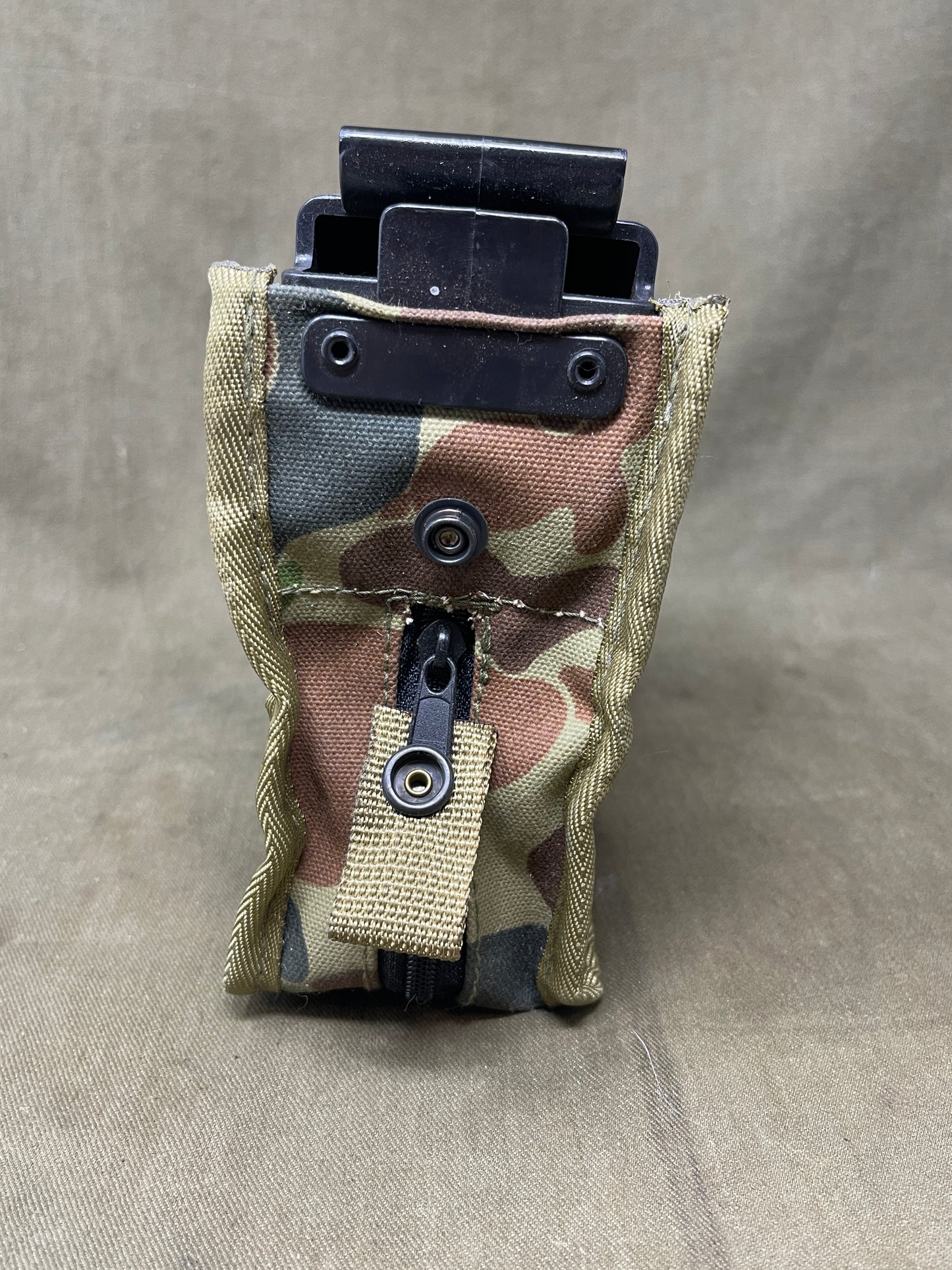 Australian Army LMG pouch, featuring the iconic Australian pattern camouflage. This pouch is designed for durability and functionality, constructed from rugged, heavy-duty materials capable of withstanding harsh field conditions. Its distinctive camouflage pattern ensures effective concealment across a variety of Australian terrains, including dense bushland and arid environments.