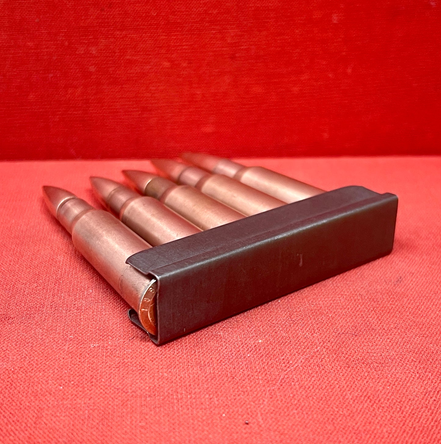 "Discover 5 authentic 7.62x54mm Russian inert cartridges on a classic stripper clip. Perfect for collectors and enthusiasts, these safe, deactivated rounds showcase military history."