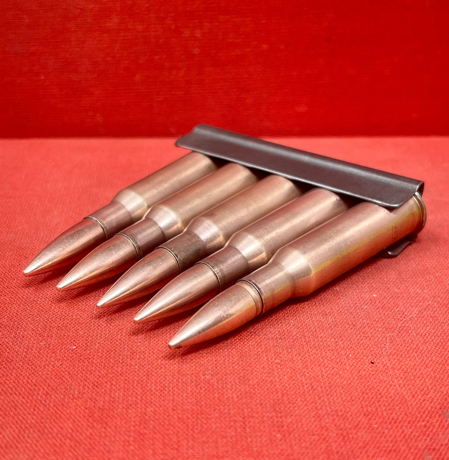"Discover 5 authentic 7.62x54mm Russian inert cartridges on a classic stripper clip. Perfect for collectors and enthusiasts, these safe, deactivated rounds showcase military history."