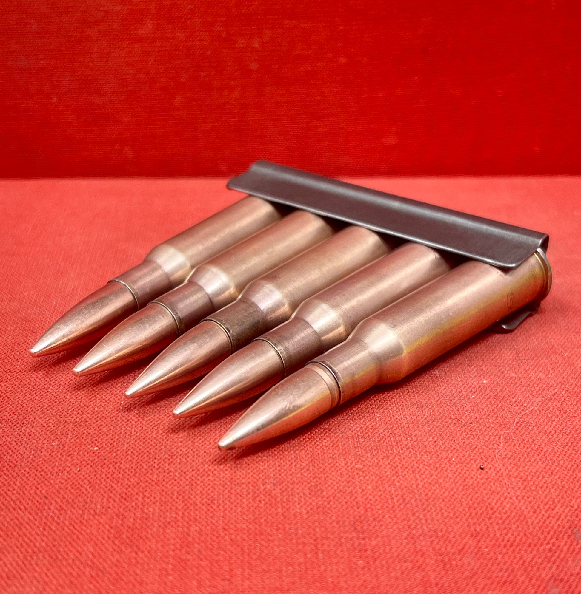 "Discover 5 authentic 7.62x54mm Russian inert cartridges on a classic stripper clip. Perfect for collectors and enthusiasts, these safe, deactivated rounds showcase military history."