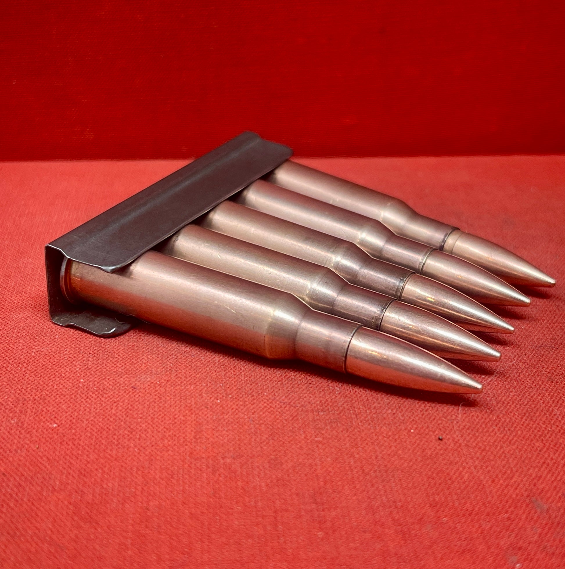"Discover 5 authentic 7.62x54mm Russian inert cartridges on a classic stripper clip. Perfect for collectors and enthusiasts, these safe, deactivated rounds showcase military history."