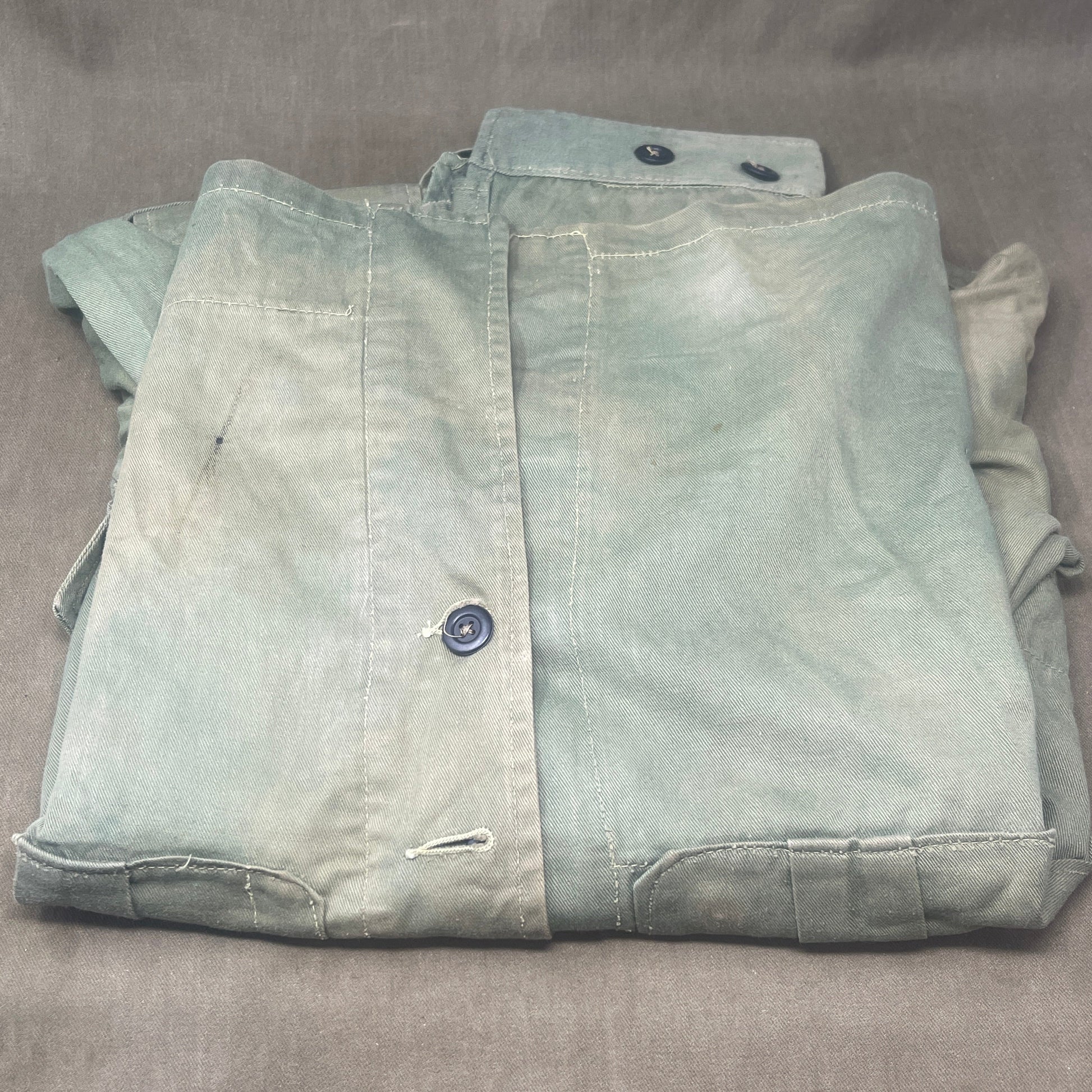 This original 1951-dated British Army Jungle Green Bush Jacket is a superb example of early post-war tropical combat clothing, manufactured by the reputable N. Lotery & Co. Ltd. Made from sturdy, breathable cotton in classic Jungle Green, this jacket was designed for use in humid and challenging environments such as Malaya and other post-war theatres of operation.

The jacket is in excellent condition, showing minimal signs of wear, with its color, stitching, and structural integrity all remarkably well-pre