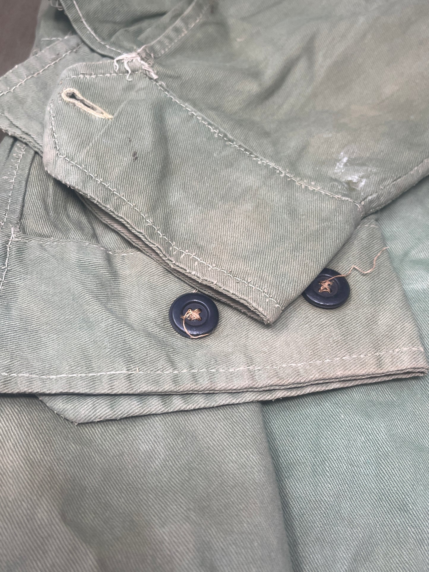 This original 1951-dated British Army Jungle Green Bush Jacket is a superb example of early post-war tropical combat clothing, manufactured by the reputable N. Lotery & Co. Ltd. Made from sturdy, breathable cotton in classic Jungle Green, this jacket was designed for use in humid and challenging environments such as Malaya and other post-war theatres of operation.

The jacket is in excellent condition, showing minimal signs of wear, with its color, stitching, and structural integrity all remarkably well-pre