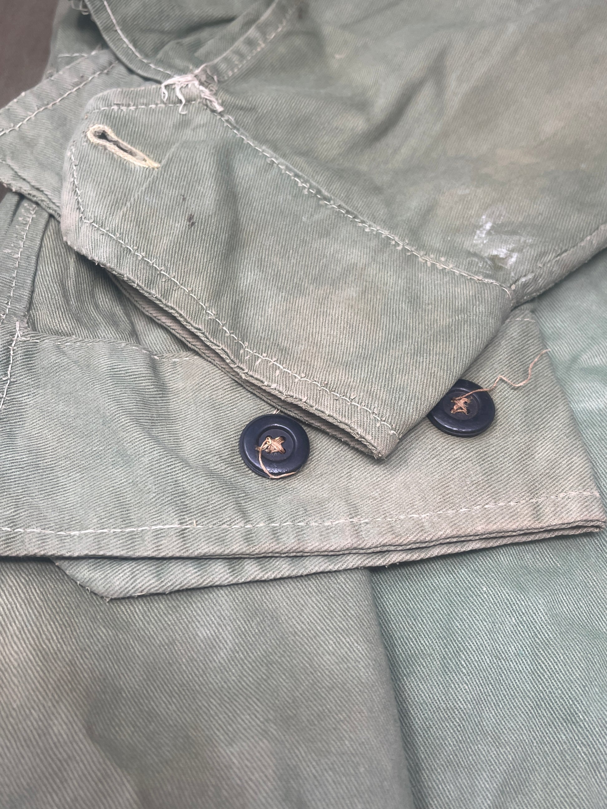 This original 1951-dated British Army Jungle Green Bush Jacket is a superb example of early post-war tropical combat clothing, manufactured by the reputable N. Lotery & Co. Ltd. Made from sturdy, breathable cotton in classic Jungle Green, this jacket was designed for use in humid and challenging environments such as Malaya and other post-war theatres of operation.

The jacket is in excellent condition, showing minimal signs of wear, with its color, stitching, and structural integrity all remarkably well-pre
