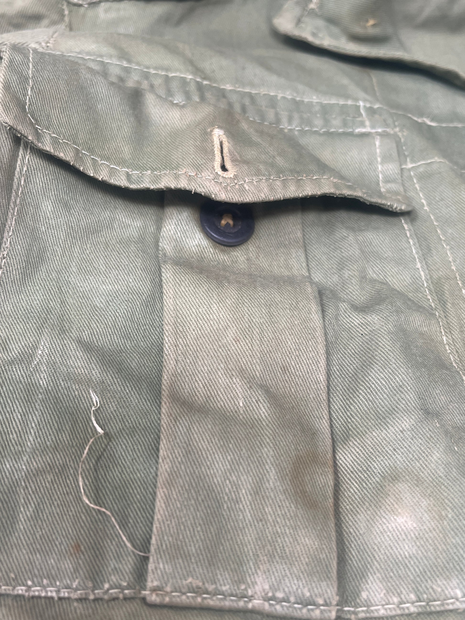 This original 1951-dated British Army Jungle Green Bush Jacket is a superb example of early post-war tropical combat clothing, manufactured by the reputable N. Lotery & Co. Ltd. Made from sturdy, breathable cotton in classic Jungle Green, this jacket was designed for use in humid and challenging environments such as Malaya and other post-war theatres of operation.

The jacket is in excellent condition, showing minimal signs of wear, with its color, stitching, and structural integrity all remarkably well-pre