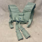 This is an original British Army 1958 Pattern Webbing Yoke, a vital component of the iconic '58 Pattern personal load-carrying system. Issued throughout the Cold War period, this yoke was designed to evenly distribute the weight of webbing pouches and equipment across the shoulders for improved comfort during extended operations.

Constructed from durable olive green webbing, the yoke features adjustable straps, metal fittings, and reinforced stitching for reliable use in the field. It connects securely to 