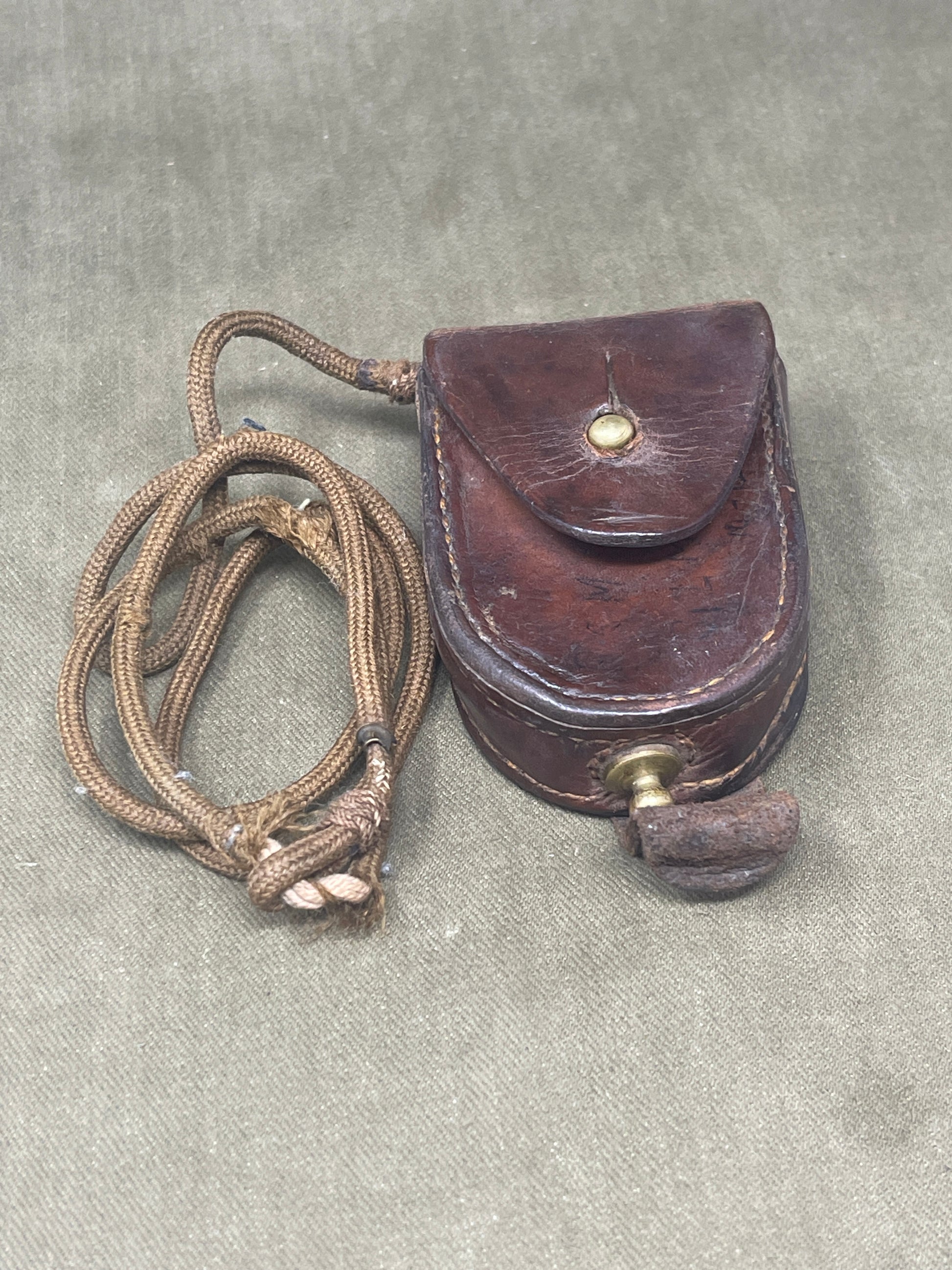This original British Military Prismatic Compass Mk III, dated 1940 and stamped with serial number NA266322, is an exceptional artifact from the Second World War. Manufactured by TG Co Ltd, a recognized wartime supplier, this compass is a classic example of durable British military engineering.

The Mk III model features a solid brass case, often finished in matte black or olive drab, designed to withstand the rigors of field use. Its prismatic sighting mechanism allows for highly accurate bearings, even in
