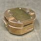 Bronze-colored metal box with a label on a gray background