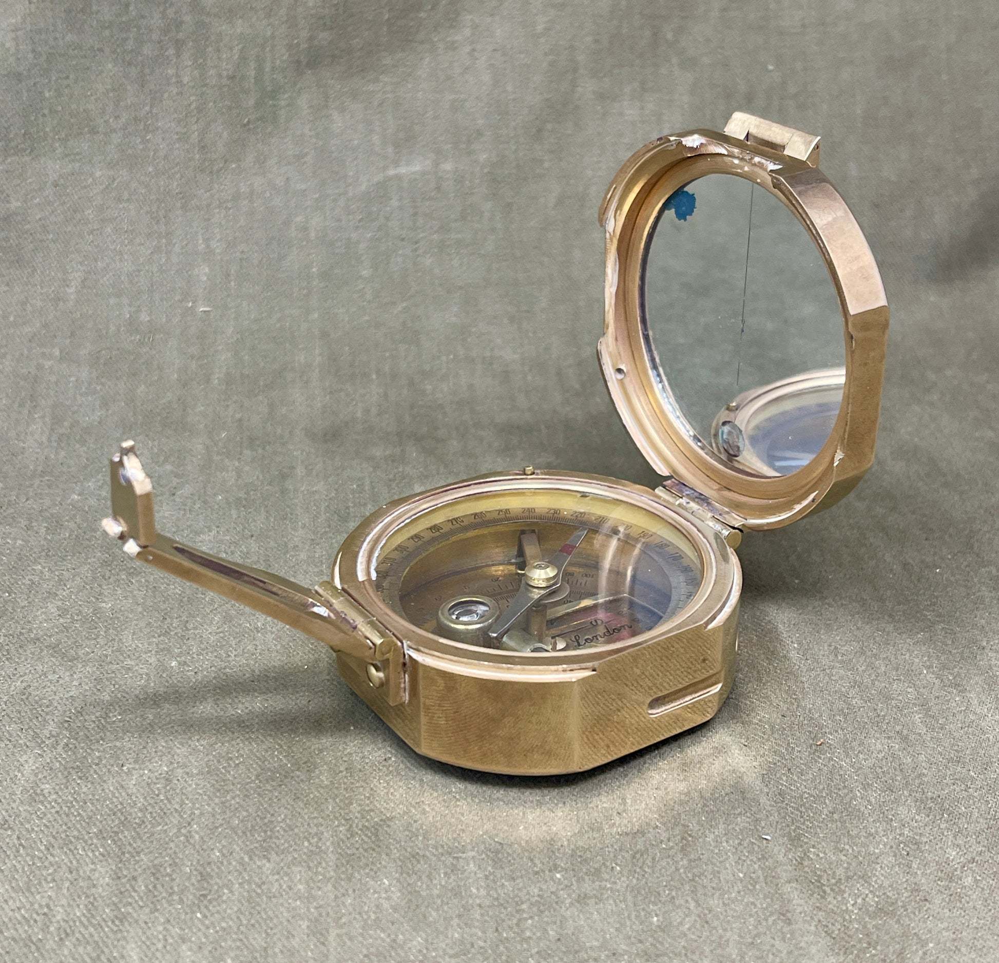 Brass compass on a gray background