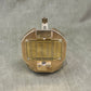 Brass mechanical device with engraved text on a gray fabric background