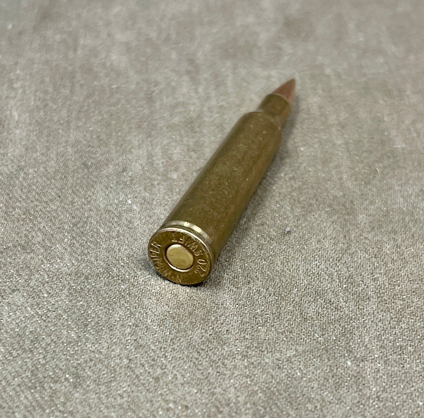 This is an original WW2-era Super .220 Swift round, professionally rendered completely inert for safe collecting and display purposes. The cartridge retains its original full metal jacketed projectile and brass casing, featuring the correct wartime Super headstamp. It has been expertly deactivated, with the primer replaced by an inert one and all propellant removed. The .220 Swift was known for its high velocity and flat trajectory, originally developed in the 1930s and occasionally used for experimental or