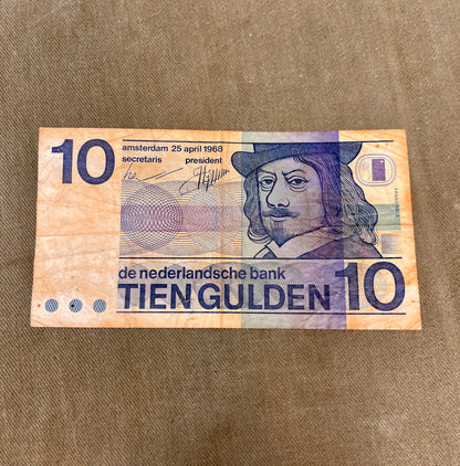 This selection of vintage Dutch Guilder banknotes from the 1960s and 1970s includes denominations of 5, 10, and 25 Gulden, each showcasing distinctive Dutch design and cultural heritage. Issued by De Nederlandsche Bank, these notes feature iconic imagery such as the statue of Erasmus (ƒ5), Baruch Spinoza (ƒ10), and Michiel de Ruyter (ƒ25), reflecting the country’s historical and intellectual legacy. Printed in bold colours and artistic styles, these notes are no longer in circulation, having been replaced b