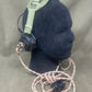 Black glove with green strap and attached cable on a gray background