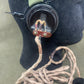 Close-up of a black object with a strap and coiled cable on a green background