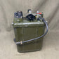 Green metal tank with mechanical components on a gray surface