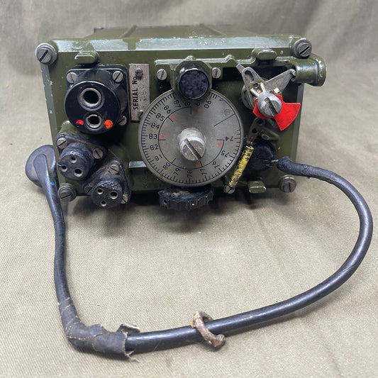 Vintage mechanical device with dials and wiring on a beige fabric background