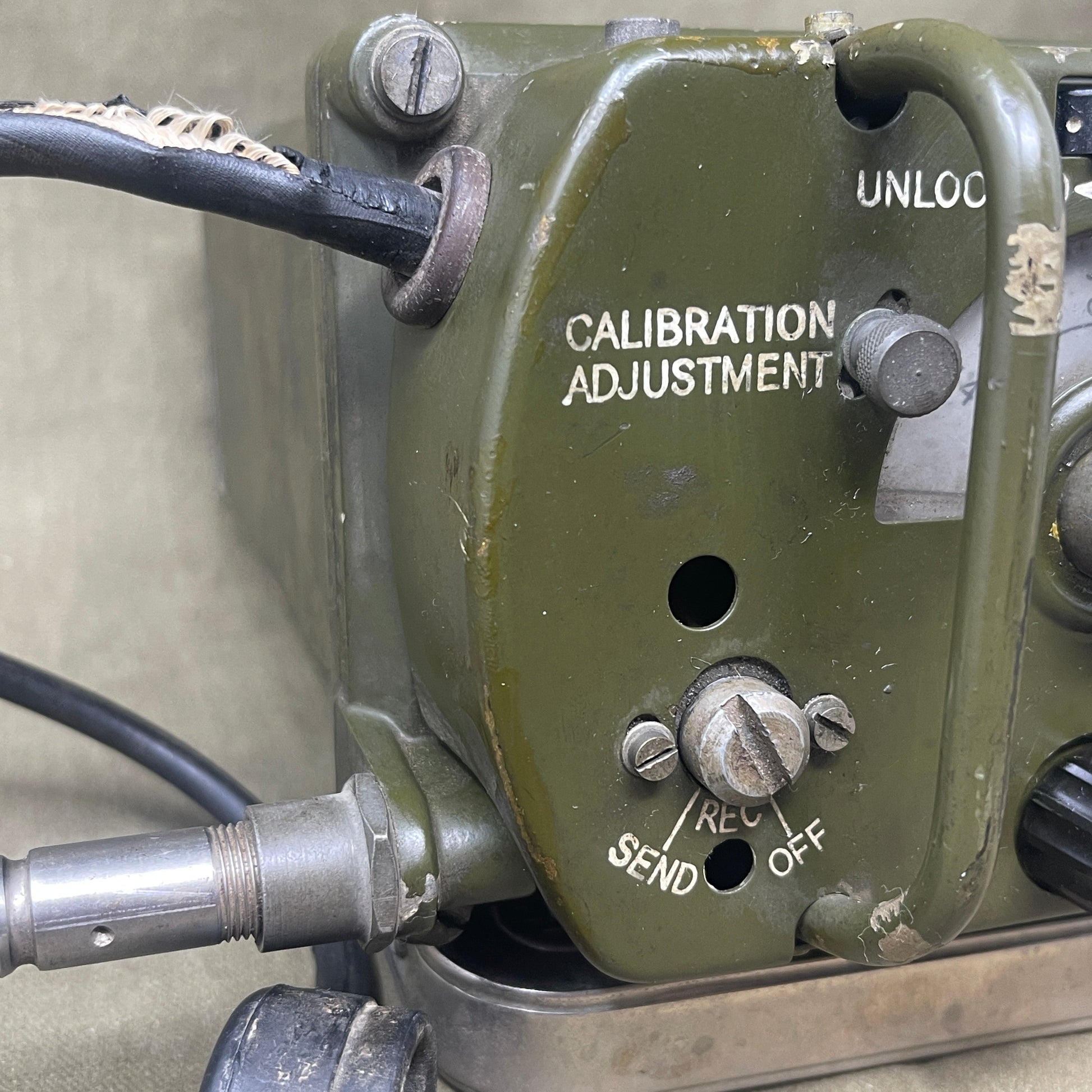 Close-up of a military-style communication device with various knobs and labels.
