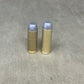Two brass bullet casings on a gray concrete surface