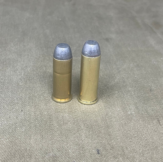 Two brass bullet casings on a gray concrete surface