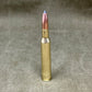 Bullet casing with a blue tip on a gray background