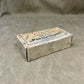 Vintage ammunition box labeled 'Parabellum' on a textured gray background