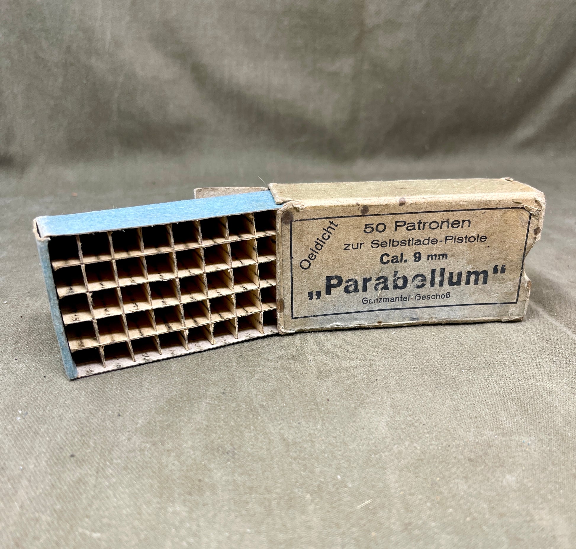Vintage Parabellum ammunition box with a magazine on a gray background