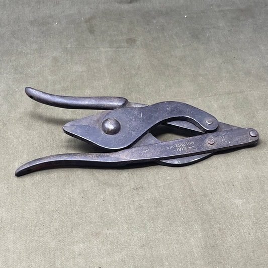 Original WWI British Wire Cutters, dated 1917 and made by Chillington, are durable steel tools with wooden handles, designed for cutting barbed wire in trench warfare. Essential for soldiers, these cutters reflect practical WWI engineering and are highly valued by collectors for their historical significance