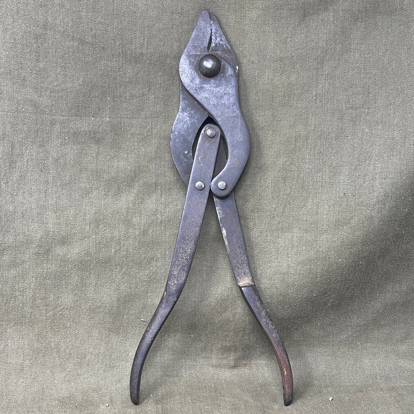 Original WWI British Wire Cutters, dated 1917 and made by Chillington, are durable steel tools with wooden handles, designed for cutting barbed wire in trench warfare. Essential for soldiers, these cutters reflect practical WWI engineering and are highly valued by collectors for their historical significance