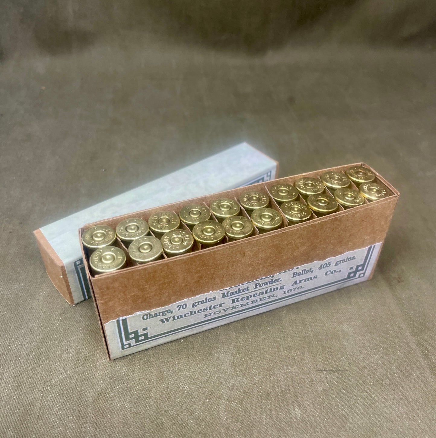 Box of ammunition with brass casings on a textured surface