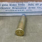 Vintage brass cartridge with a label in the background