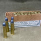 Box of Winchester Repeating Arms Co. ammunition with three cartridges in front on a gray background