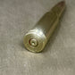Metallic bullet casing on a gray surface