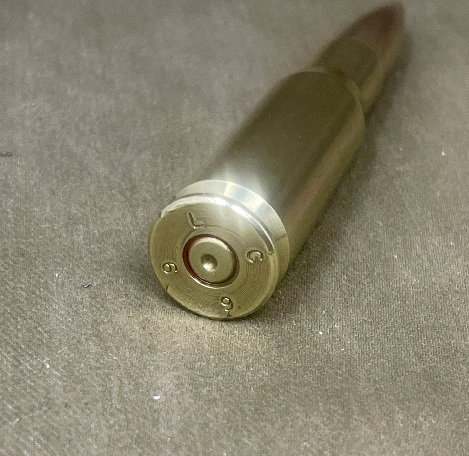 Metallic bullet casing on a gray surface