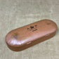 Brown eyeglass case with 'A & M Levers' branding on a textured surface