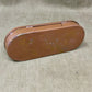 Brown oval metal object on a beige fabric background