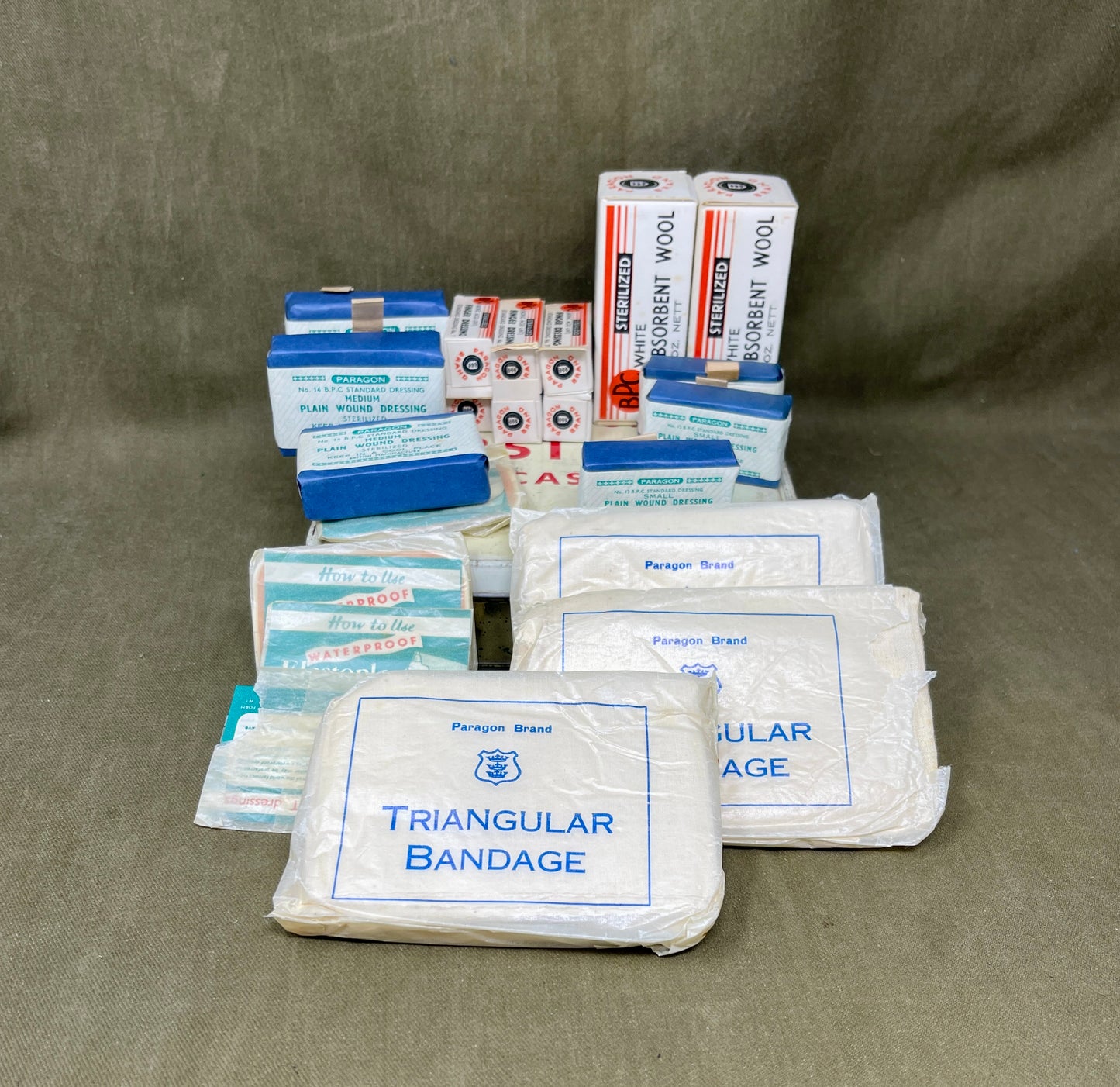 Collection of medical supplies including triangular bandages and other包扎材料 on a brown background