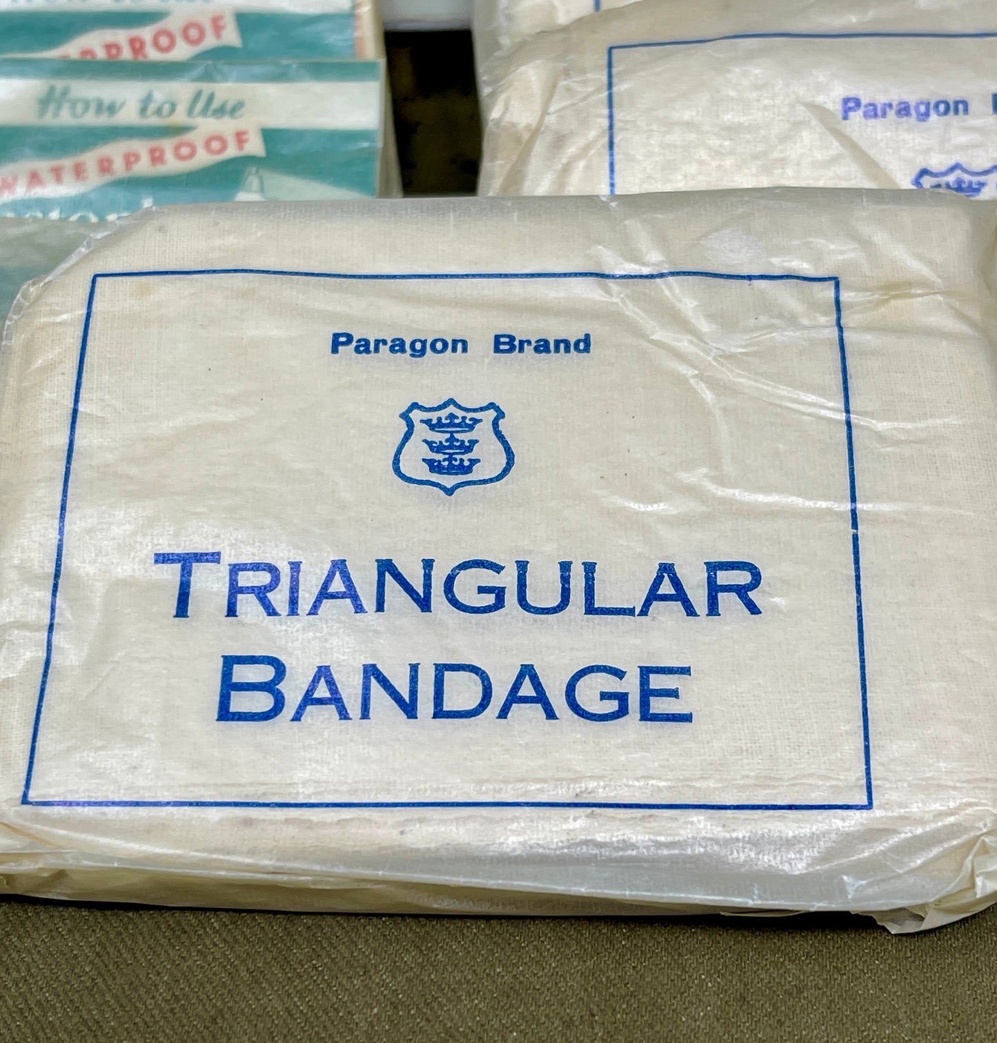 Packaged Paragon Brand triangular bandage on a textured surface