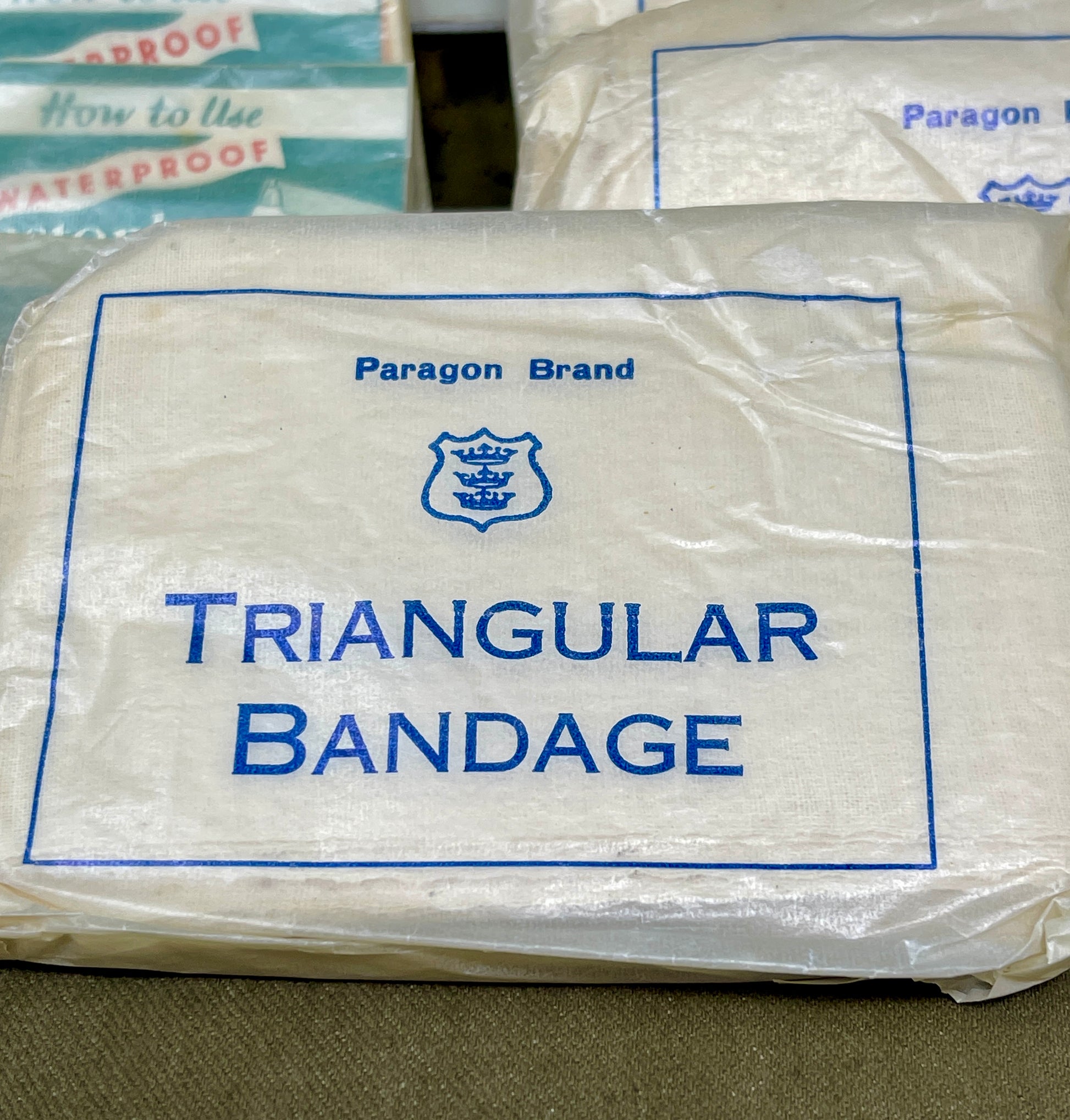 Packaged Paragon Brand triangular bandage on a textured surface